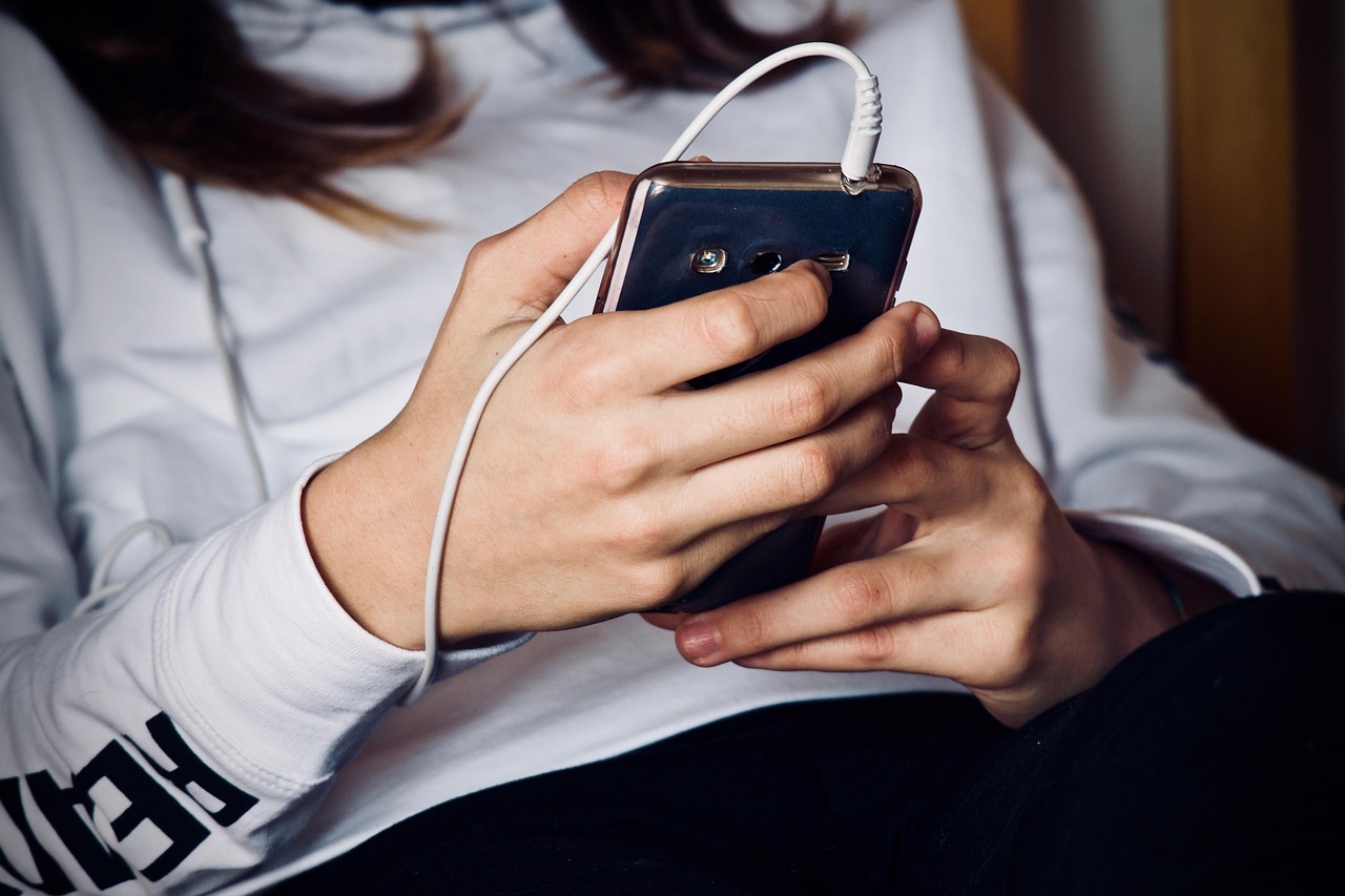 Two people sitting together looking at a mobile screen for a shared payment.