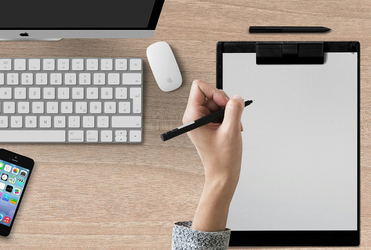 A hand checking off boxes on a paper checklist with a pen.