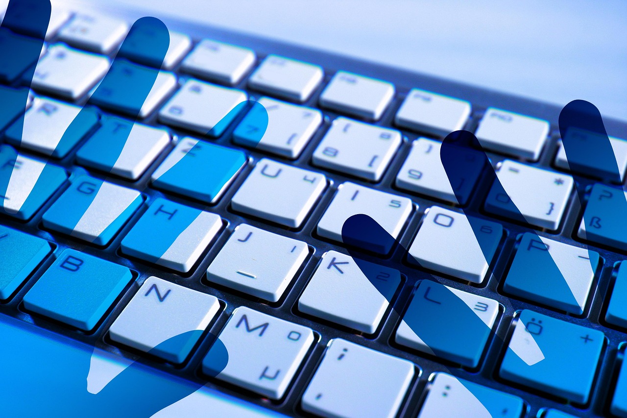 A glowing blue digital security overlay on a laptop keyboard representing ACH transfer identity matching.