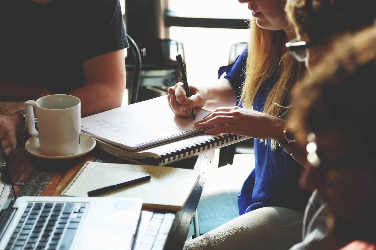 A professional financial advisor discussing a portfolio with a couple in a bright office.
