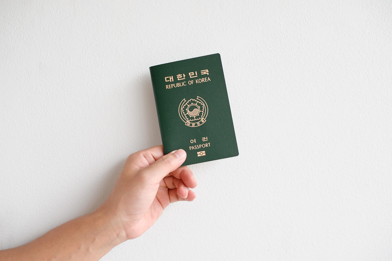 A passport and airplane ticket next to a set of dental crowns representing dental tourism.