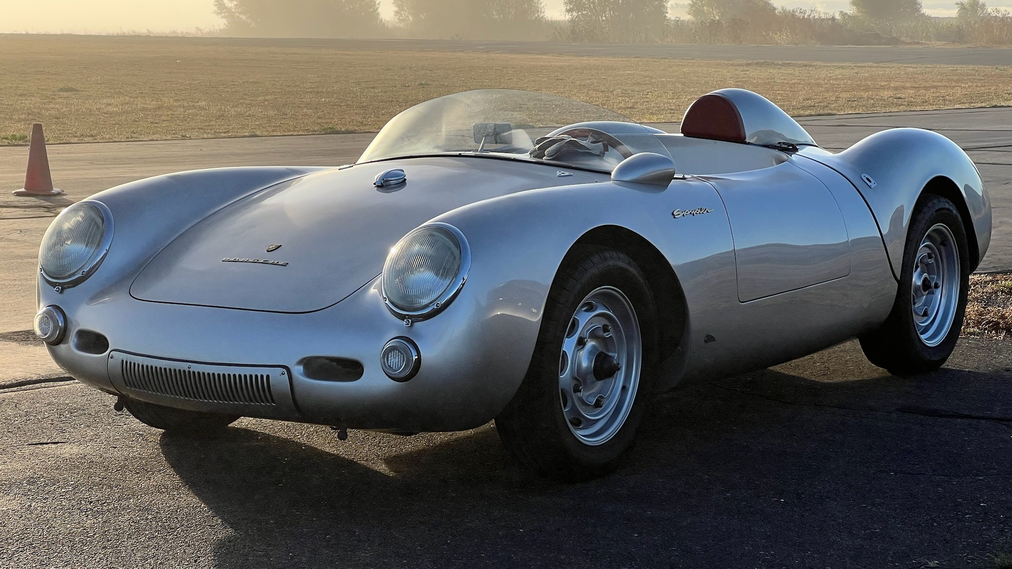 A silver classic Porsche-style sports car parked outdoors.