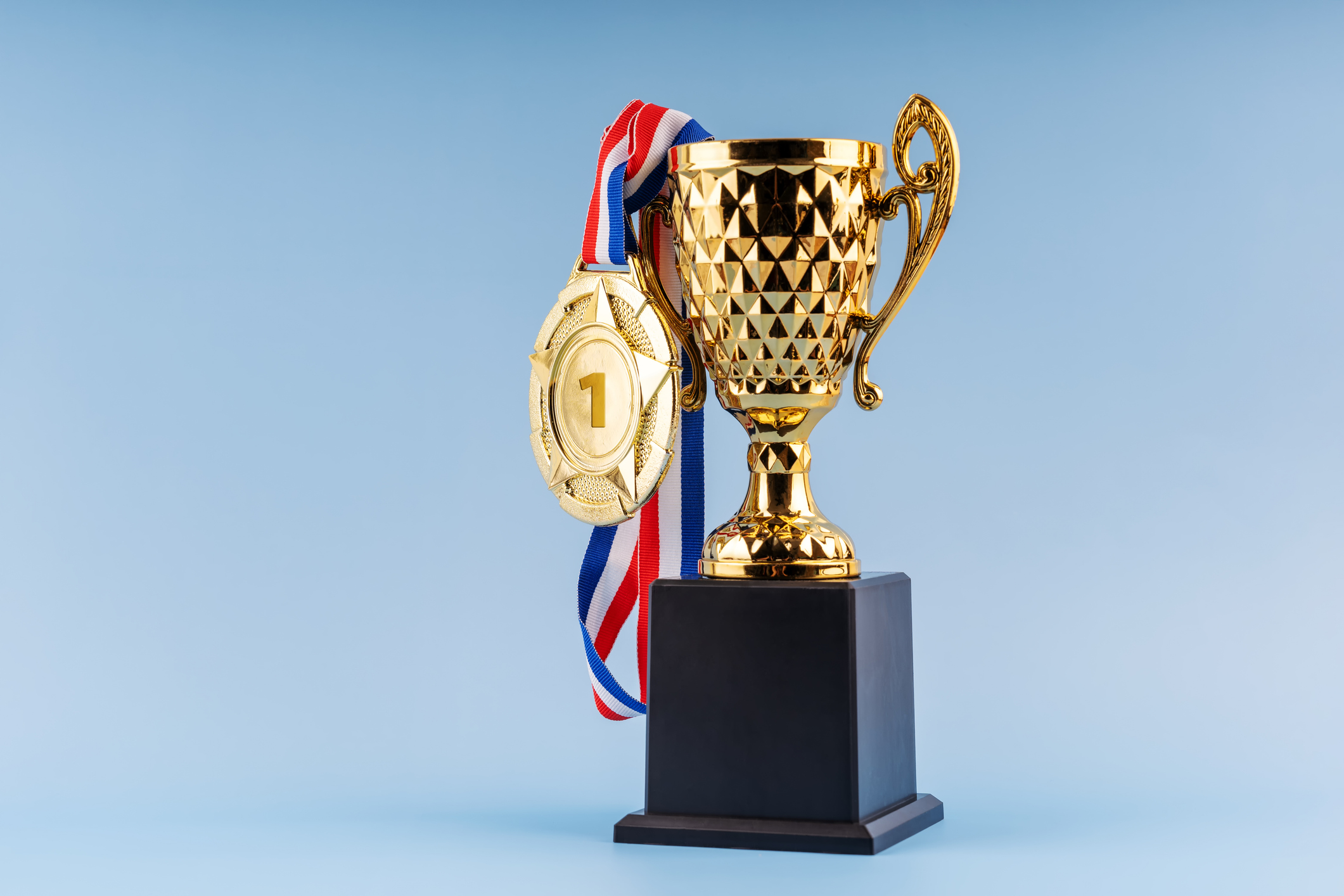 A gold trophy award with a gold medal hanging from it, symbolizing high-value assets.