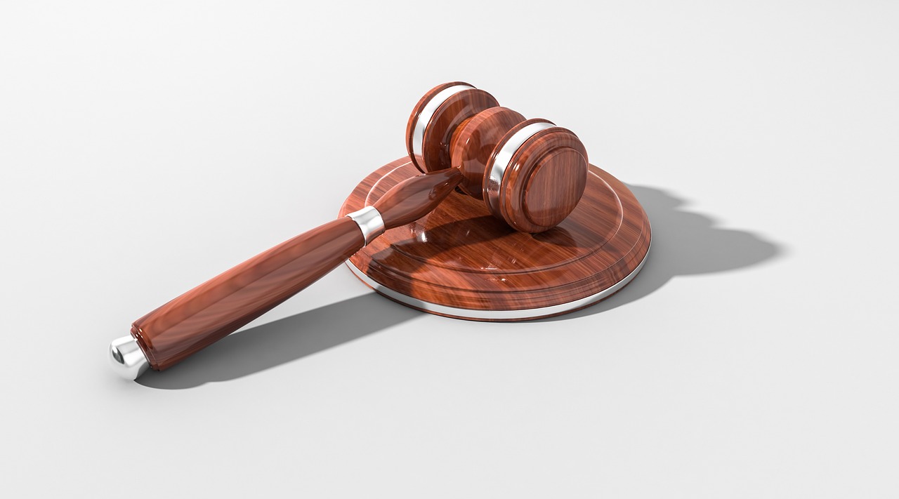 A wooden gavel resting next to a small house model, symbolizing legal protection for homeowners.