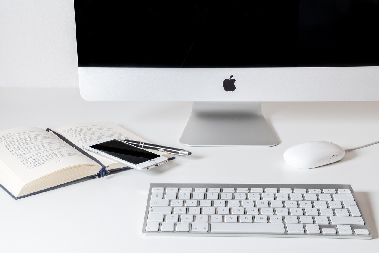 A hand checking off items on a professional checklist at an organized office desk.