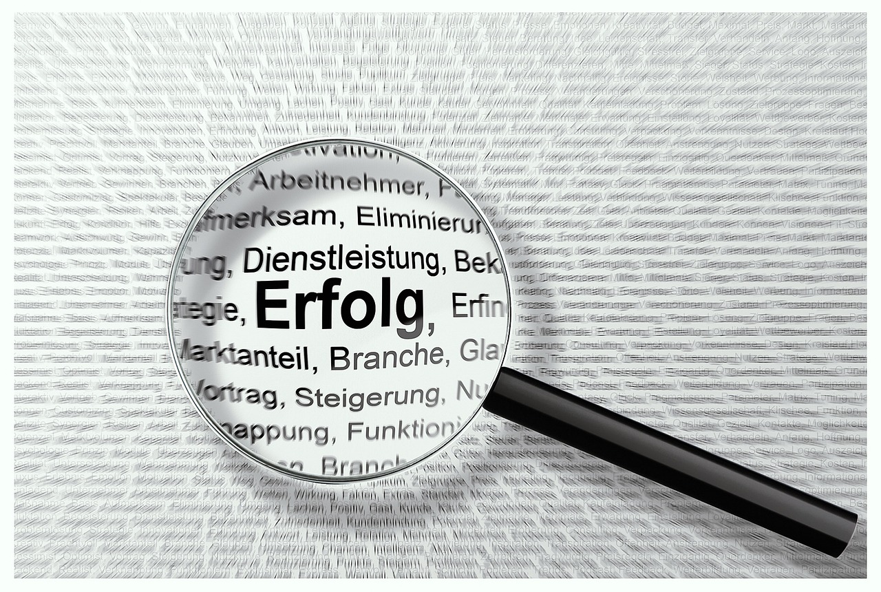 A hand holding a magnifying glass over a detailed financial document