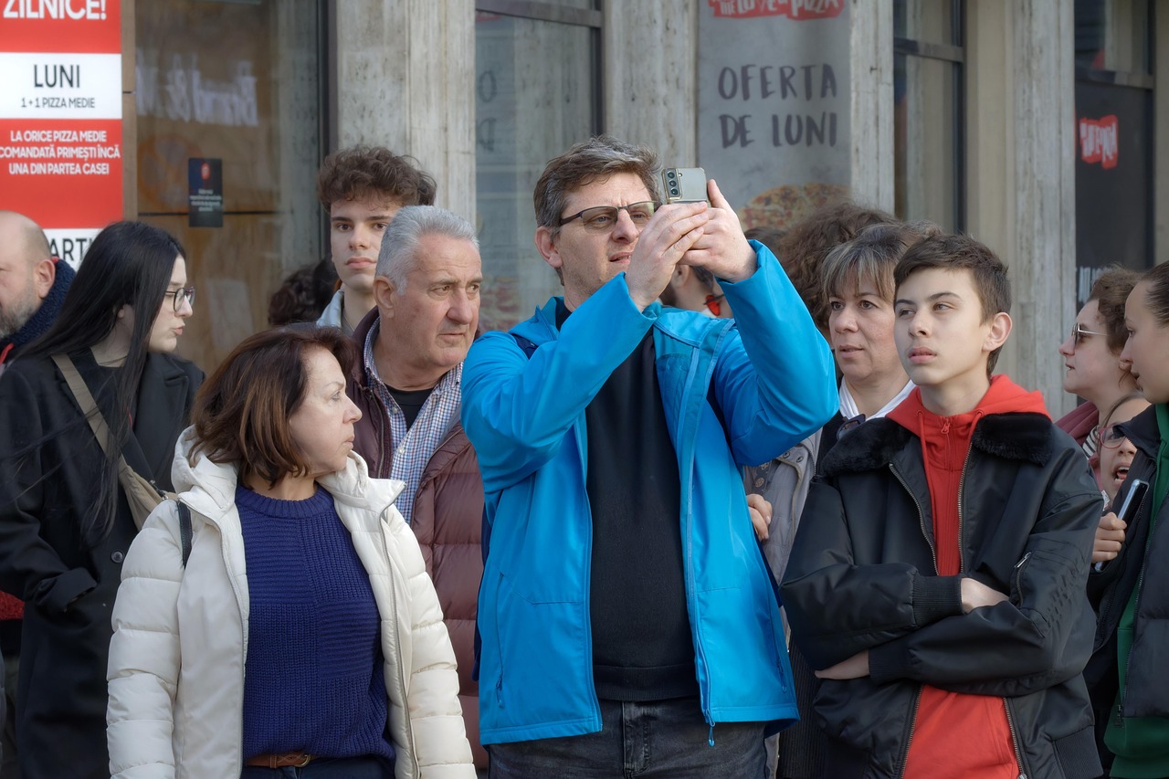 A person using a smartphone to take a clear photo of a vehicle's license plate at an accident scene.