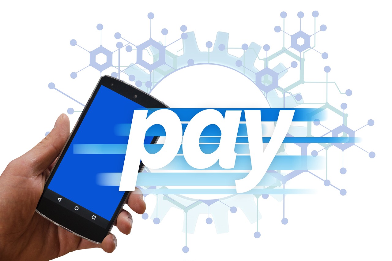 A hand holding a smartphone over a check to initiate a mobile deposit.