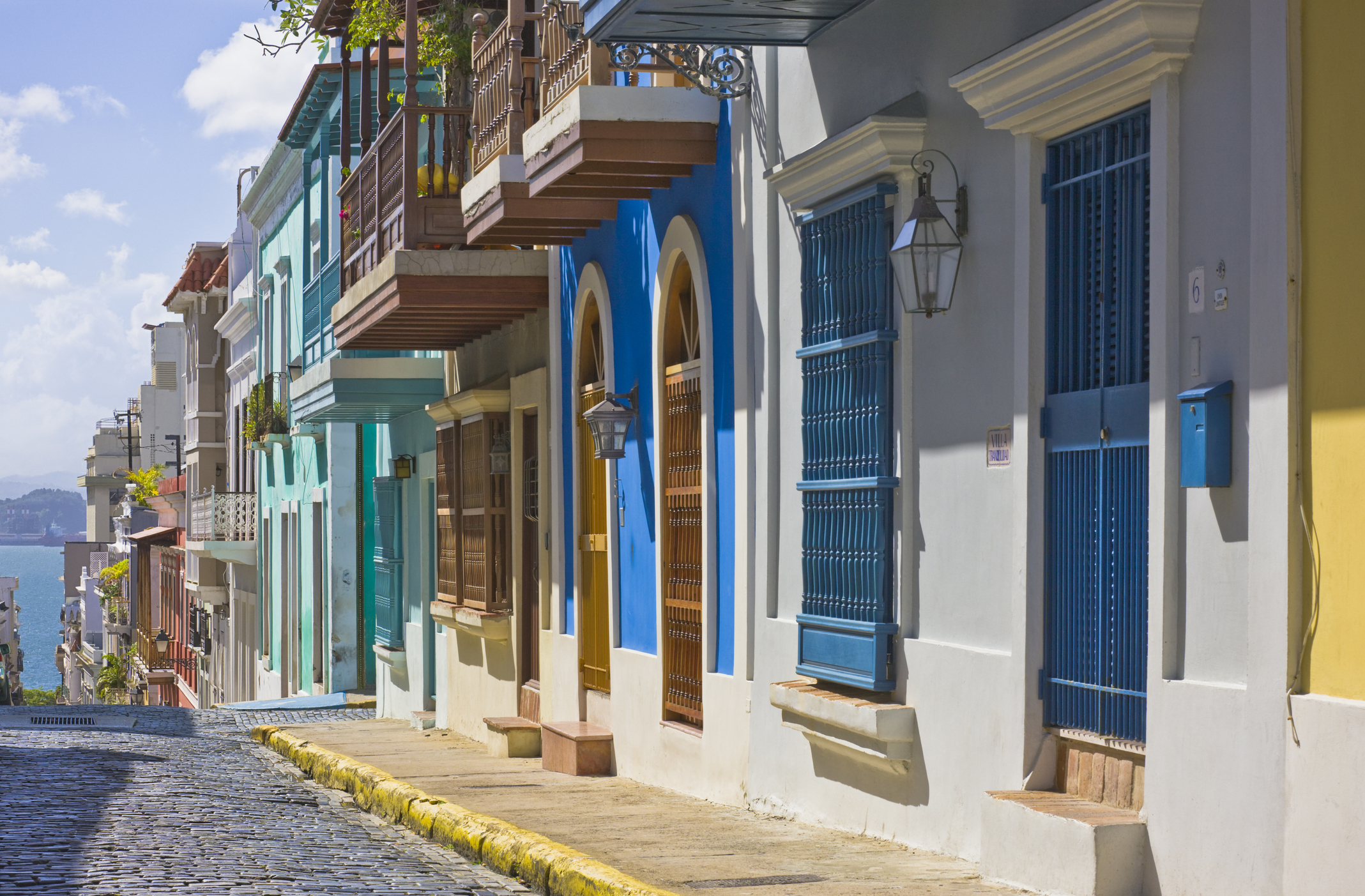 A vibrant, colorful street view of Calle San Justo in Old San Juan, Puerto Rico.