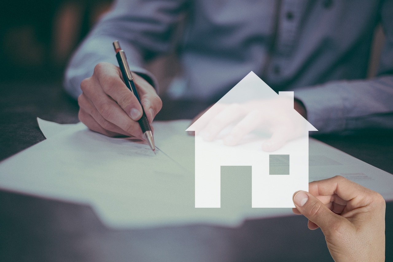 A person reviewing a car insurance policy document with a pen in hand.
