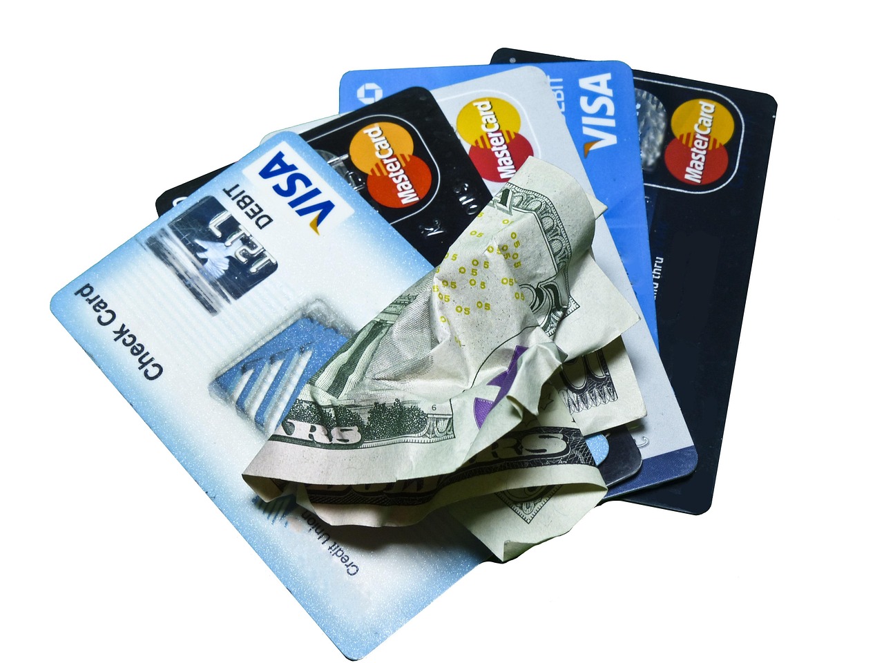 A hand holding a debit card near an ATM machine