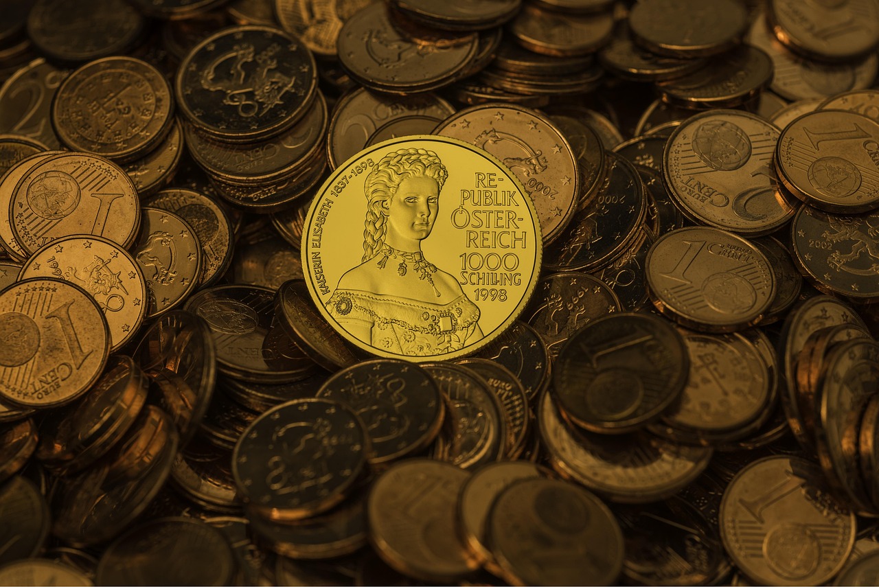 A metal shield standing next to a stack of gold coins representing financial security.