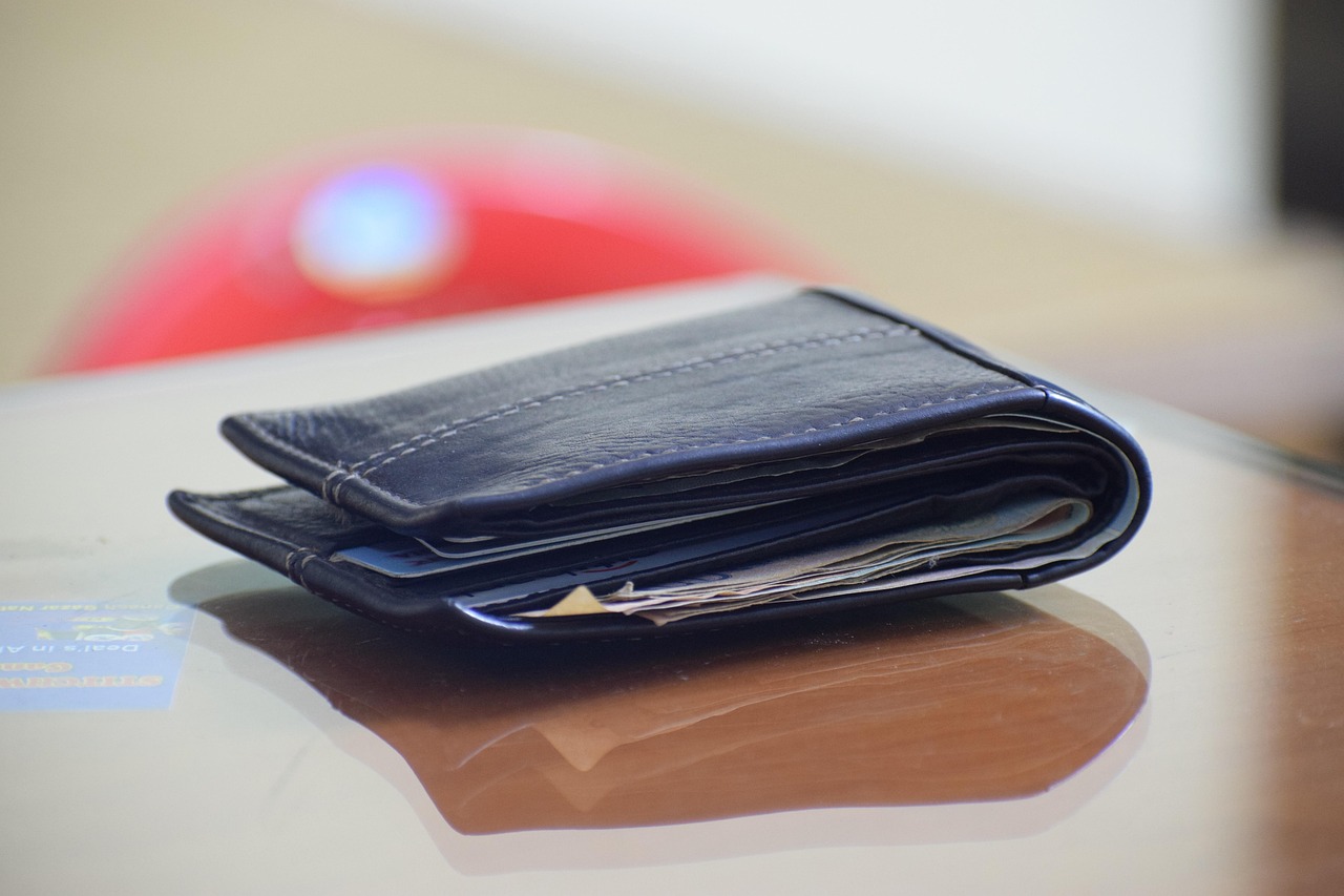 A leather wallet filled with various colorful credit and store cards.