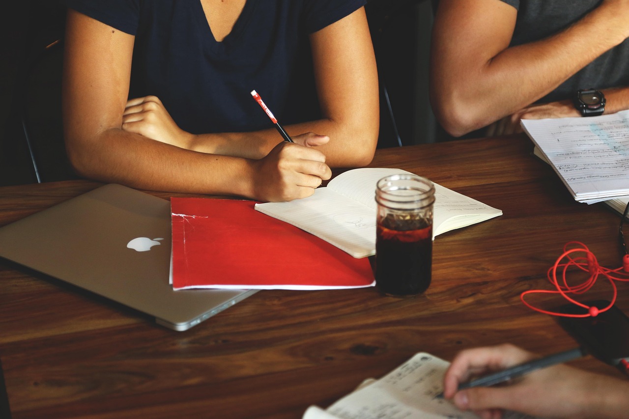 Two professionals discussing a file in a modern conference room.