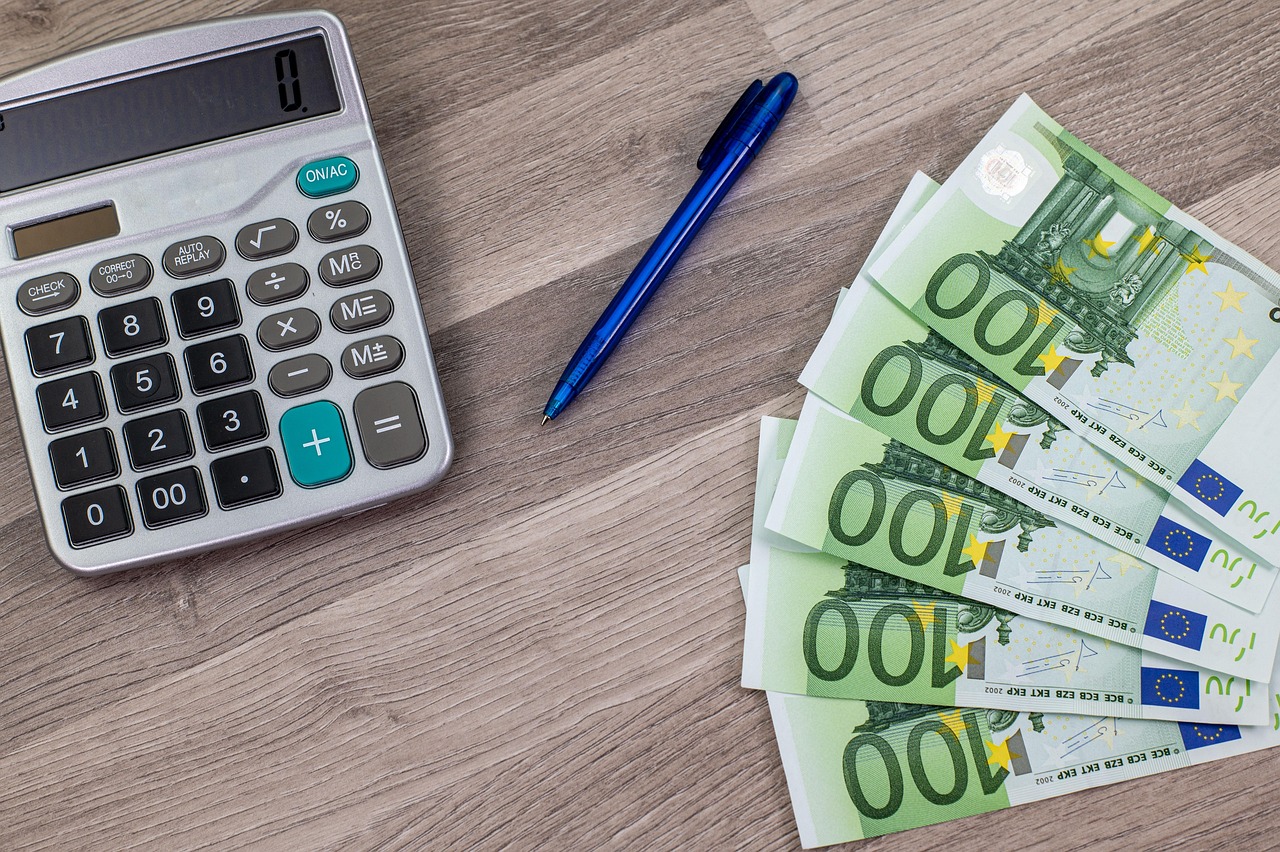 Financial documents with a calculator and a fountain pen signifying detailed review.