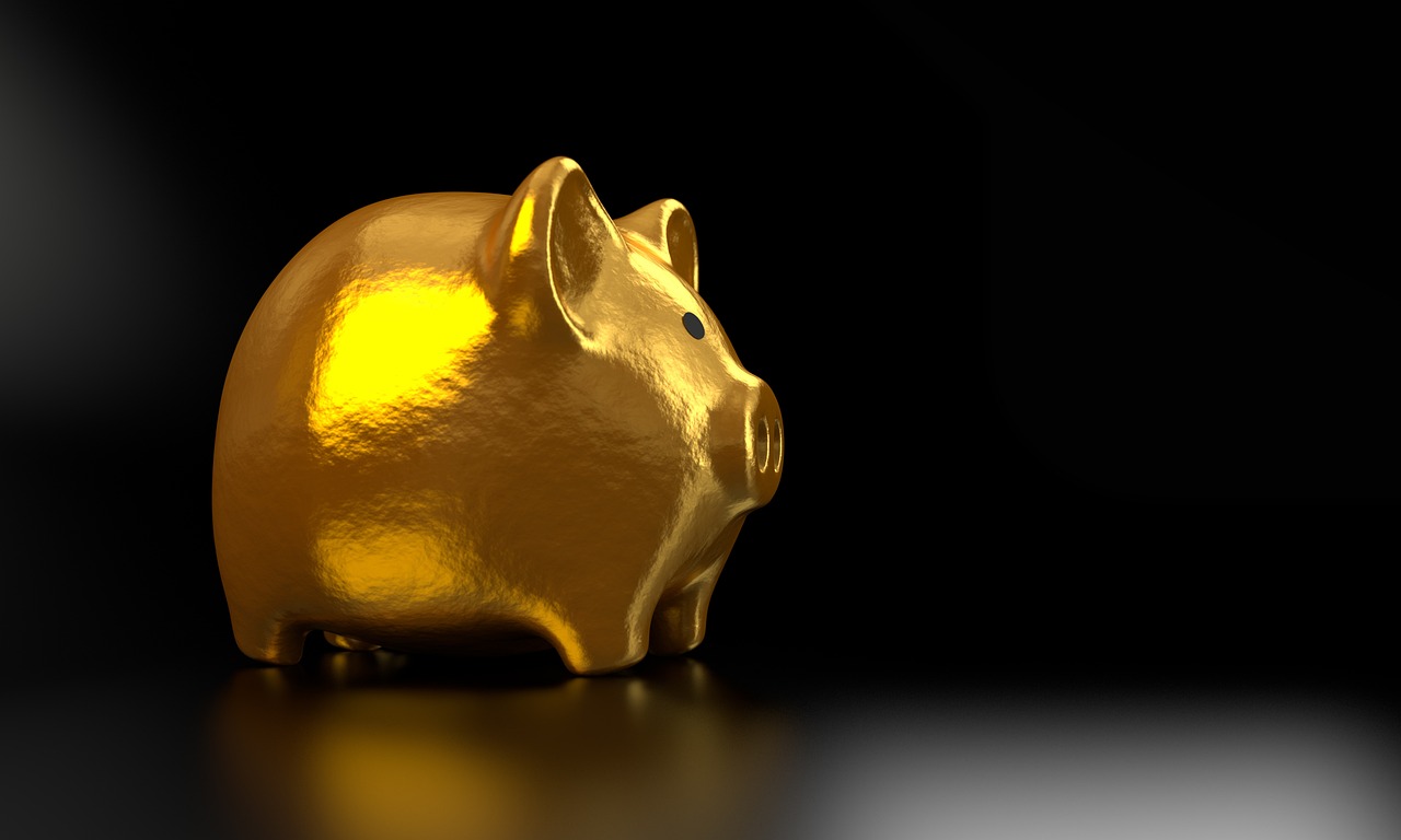 A white piggy bank with gold coins symbolizing the start of a savings journey.