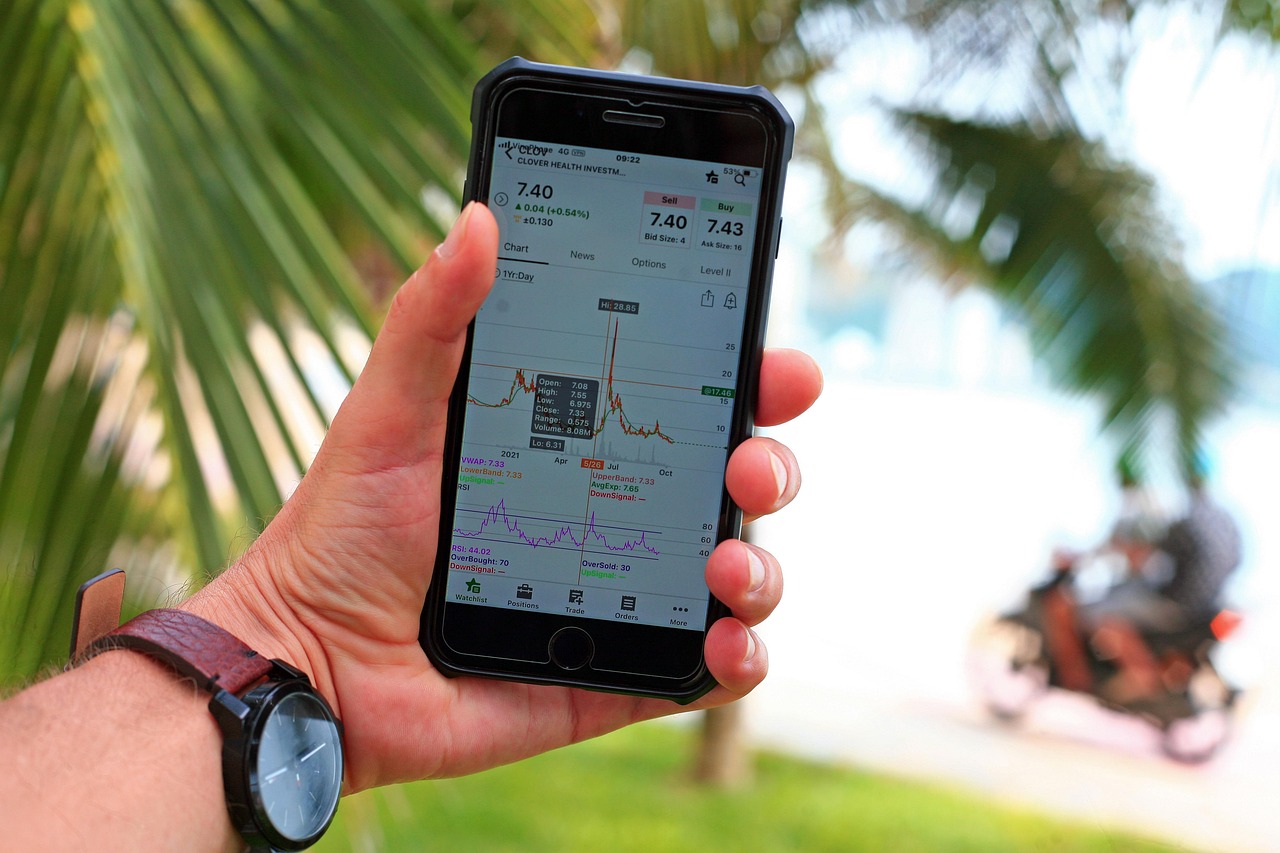 A person using a smartphone to monitor stock market performance on a trading application.