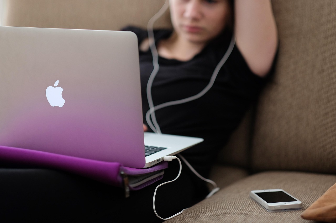 A person using a laptop comfortably at home to access customer support services.