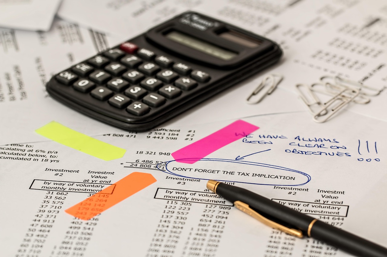 A calculator sitting next to car keys and financial estimate documents.