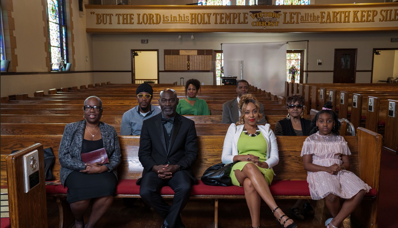 A diverse group of church members sitting in wooden pews during a service.