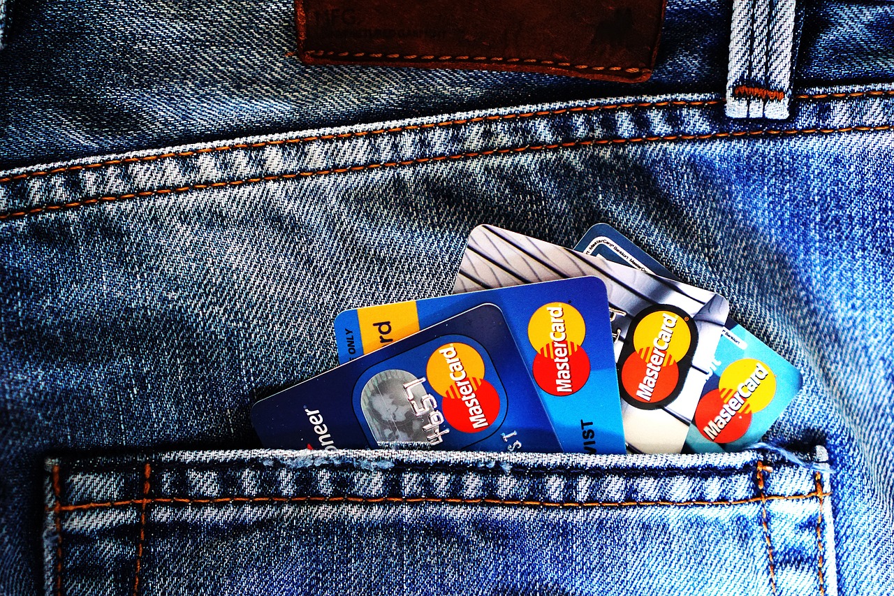 A pair of scissors cutting through a plastic credit card to signify debt termination.