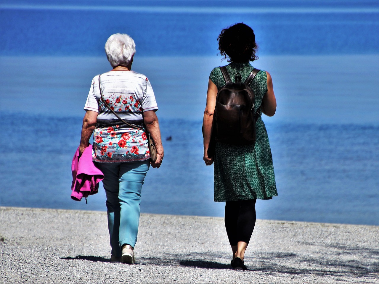 An active senior couple walking along a beach at sunset, representing a successful retirement.