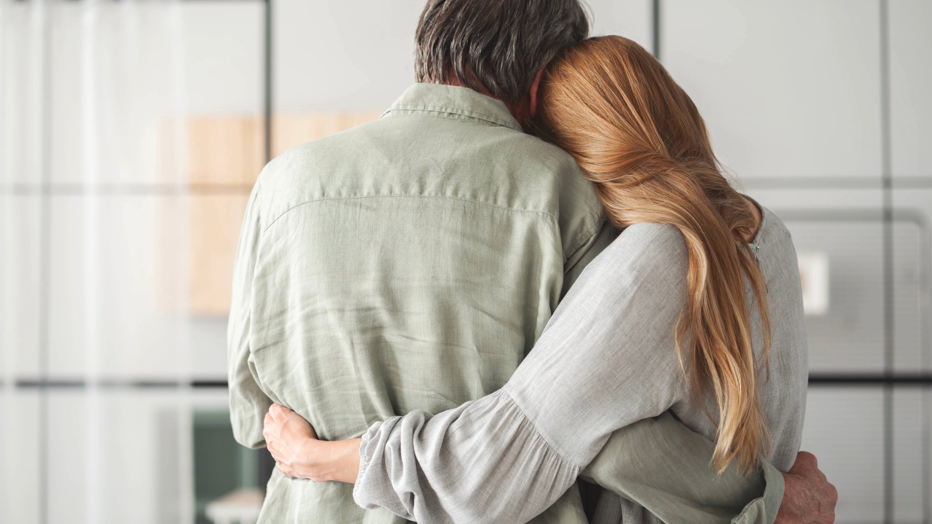 An emotional scene showing a daughter giving her father a supportive hug, illustrating familial bonds.
