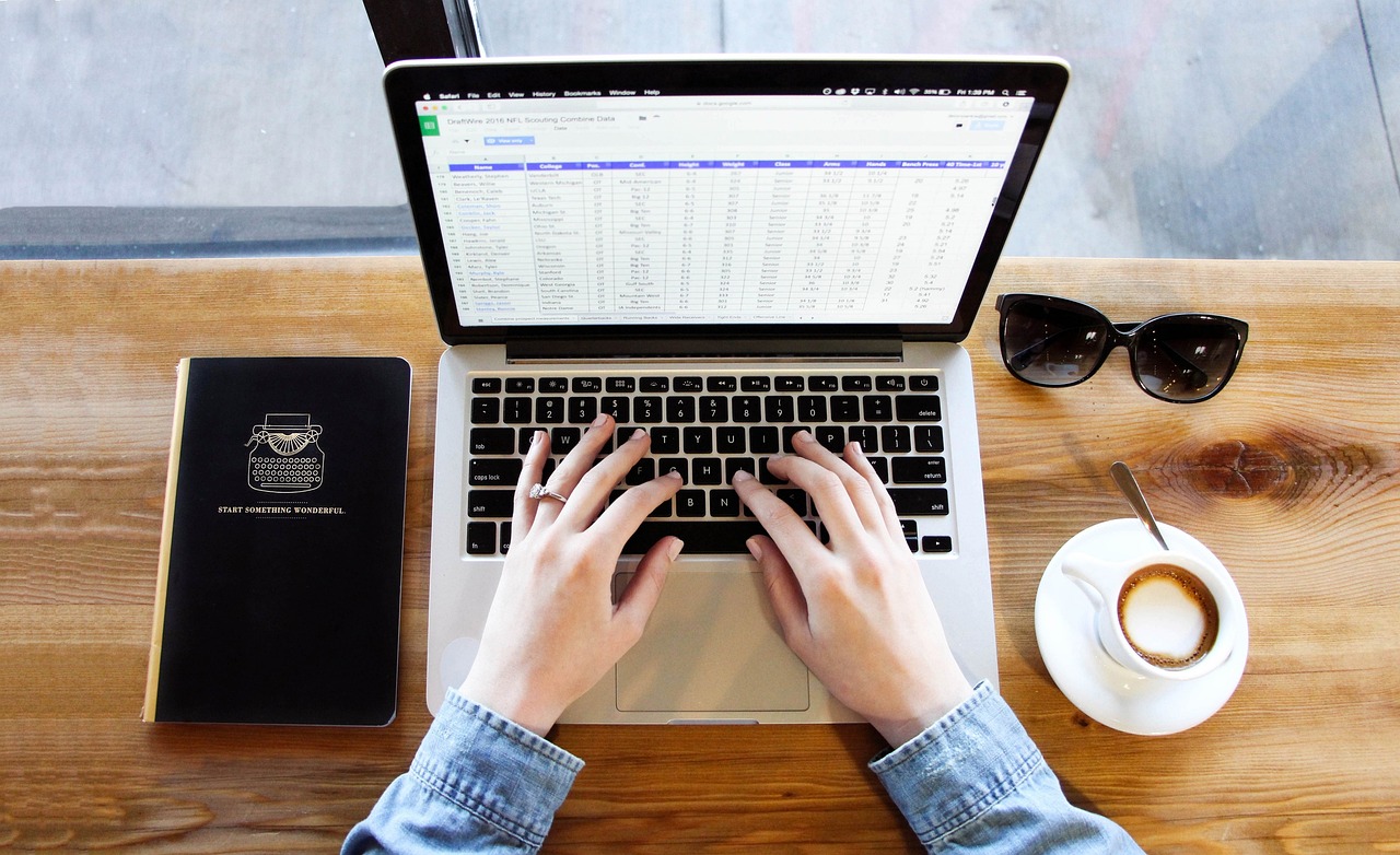 Close-up of hands typing a professional email on a laptop.