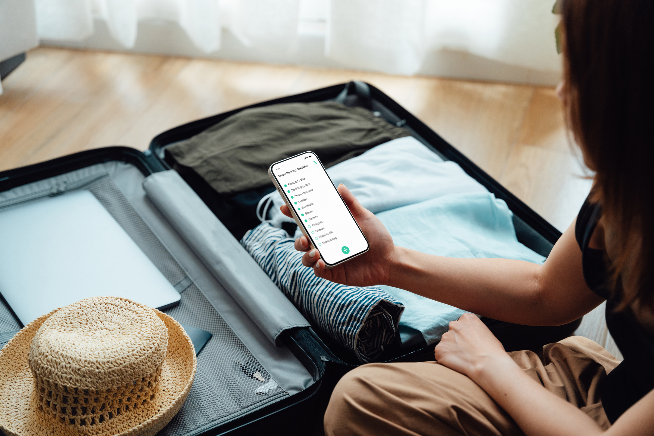 A person holding a travel checklist and preparing for a trip with documents in hand.