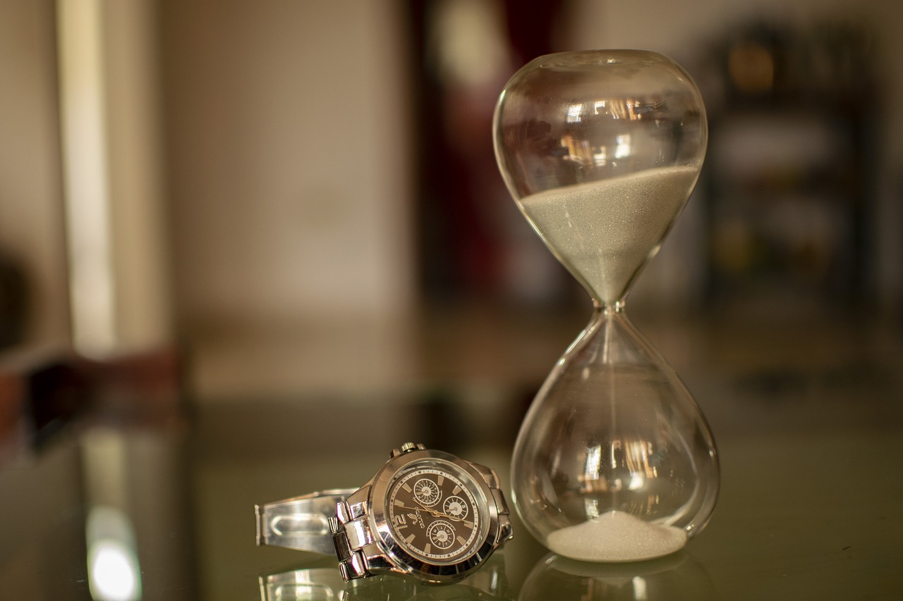 An hourglass on a desk showing the passage of time for credit eligibility