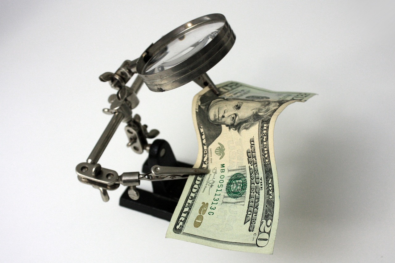 A magnifying glass focusing on specific figures on a financial spreadsheet symbolizing a detailed credit audit.