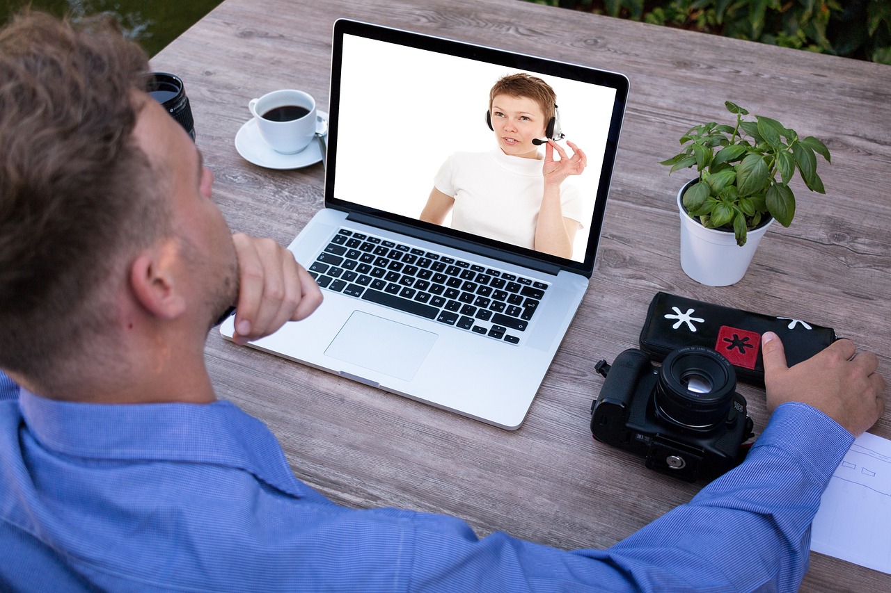 A professional customer service representative working on a laptop with a headset.