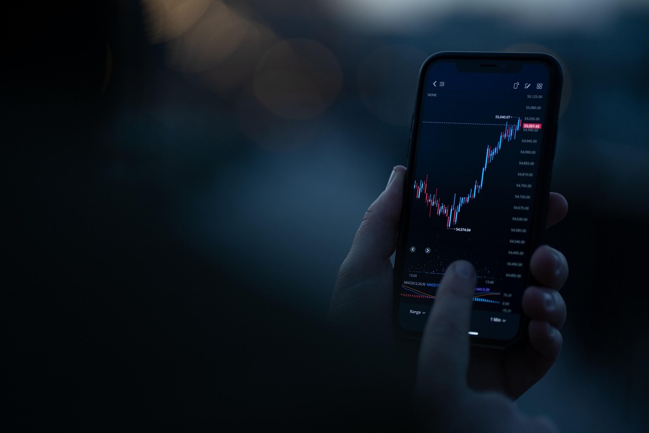 A person holding a smartphone displaying a clean, modern financial growth chart app.