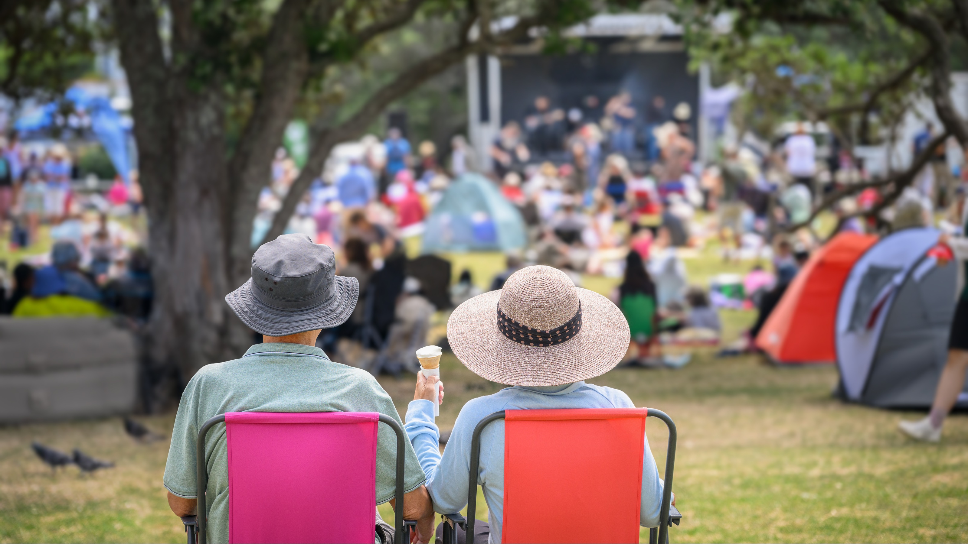 An older couple sitting in chairs outdoors, relaxing and enjoying personal time.