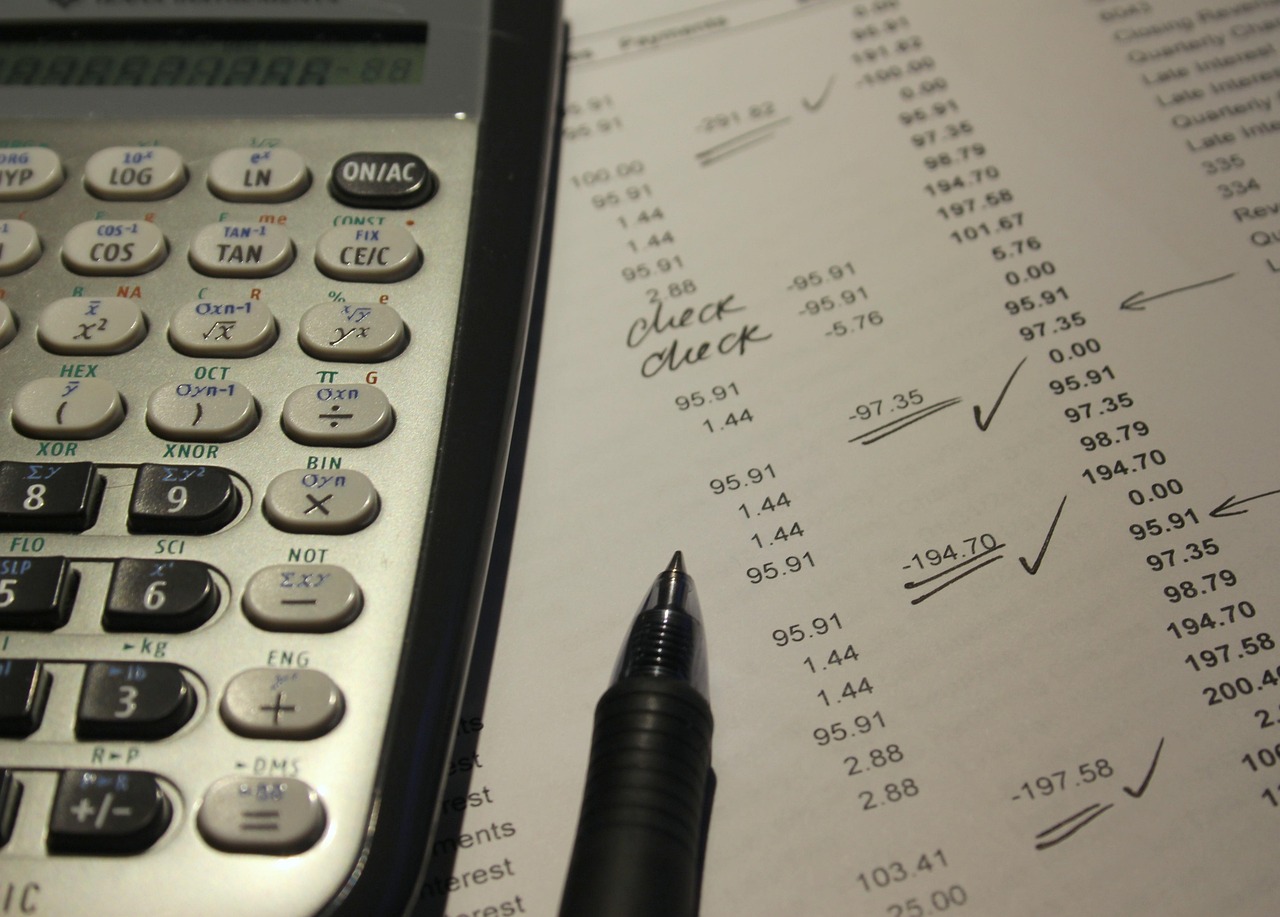 A calculator sitting on top of detailed financial growth charts and credit report papers.