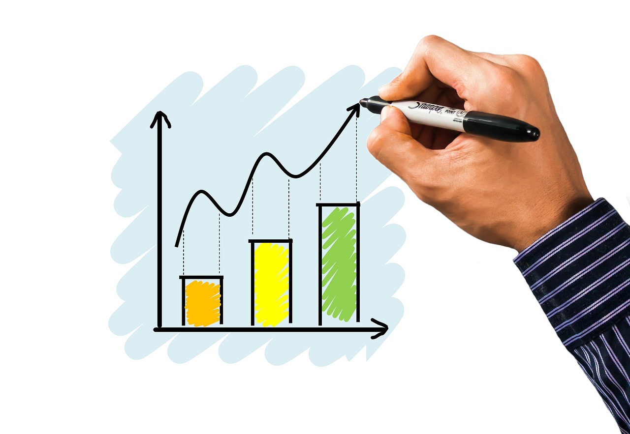 A digital screen showing a rising financial graph with a green arrow pointing upwards.